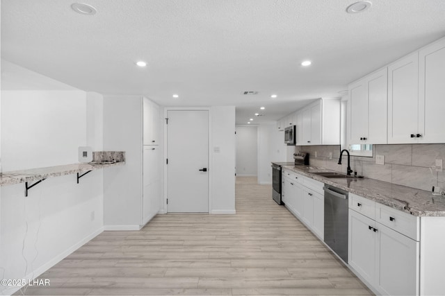 2870 Cisco Dr S, Lake Havasu City, AZ 86403 - kitchen featuring stainless steel appliances, light wood-style floors, white cabinetry, light stone counters, and recessed lighting