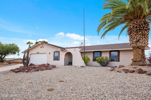 view of front of home with a garage, driveway, and stucco siding