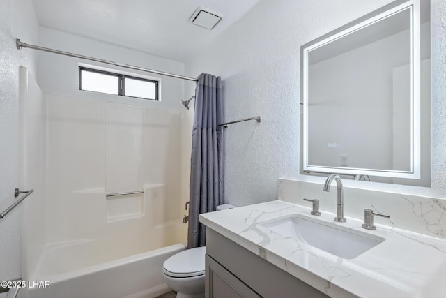 bathroom with toilet, shower / tub combo, vanity, and a textured wall