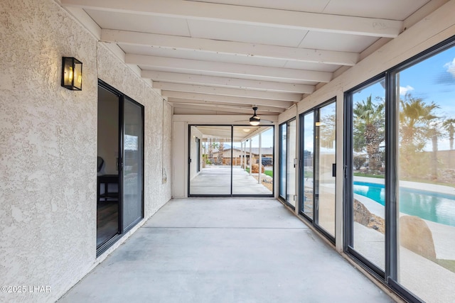 unfurnished sunroom featuring beamed ceiling