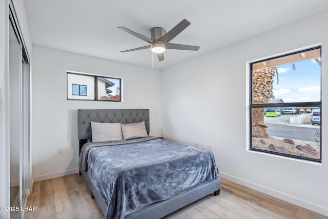 bedroom with wood finished floors, a ceiling fan, and baseboards