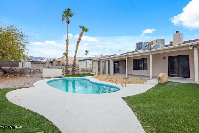 view of swimming pool with central AC unit, a fenced in pool, fence, a yard, and a patio area