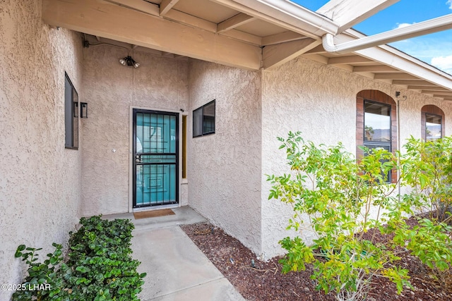 doorway to property featuring stucco siding