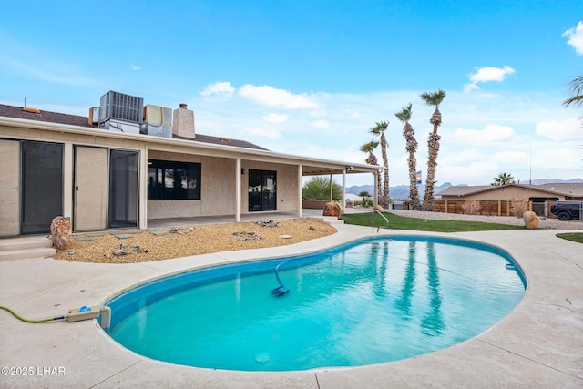 view of swimming pool featuring a patio area, cooling unit, a fenced in pool, and fence