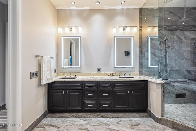 bathroom featuring a sink, a stall shower, and double vanity