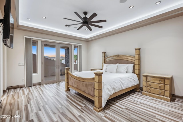 bedroom with access to exterior, recessed lighting, french doors, and a tray ceiling