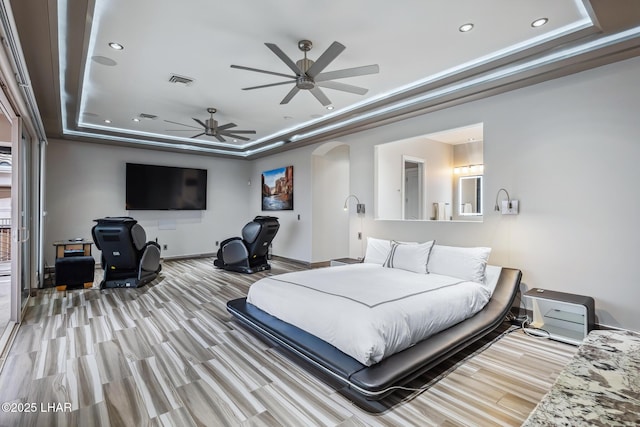 bedroom featuring arched walkways, visible vents, recessed lighting, and a raised ceiling