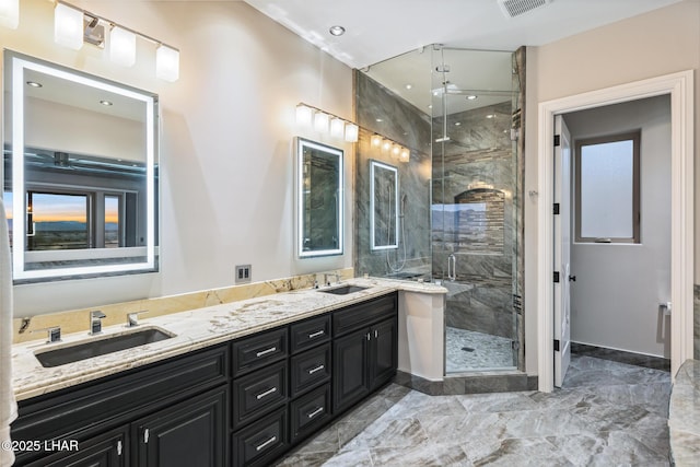 full bath with double vanity, a stall shower, ceiling fan, and a sink