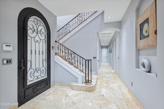 entryway featuring arched walkways, stairway, recessed lighting, and baseboards