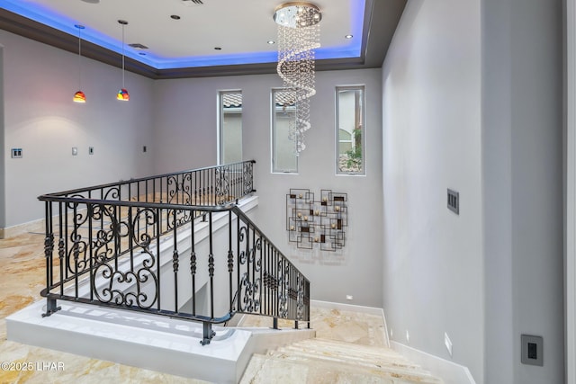 stairway with visible vents, baseboards, recessed lighting, a notable chandelier, and a raised ceiling