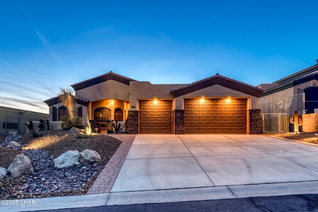 view of front facade with concrete driveway, a garage, stone siding, and stucco siding