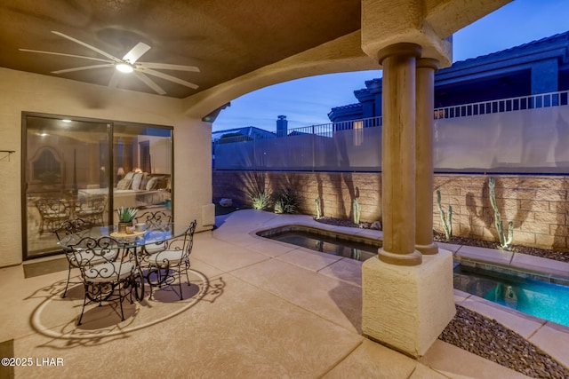 view of patio / terrace with a jacuzzi, fence, a fenced in pool, and ceiling fan