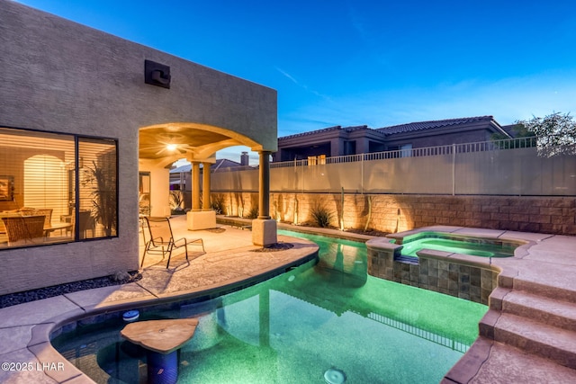 view of swimming pool with a patio, fence, and a pool with connected hot tub