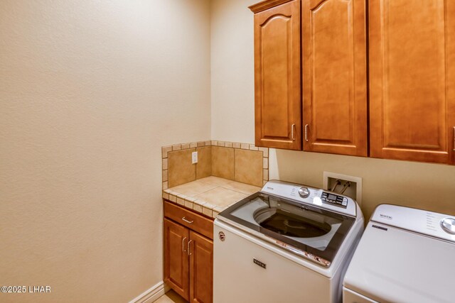 clothes washing area with cabinet space, baseboards, and separate washer and dryer