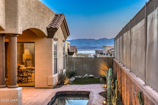 view of swimming pool featuring a patio area, a pool, a fenced backyard, and a mountain view