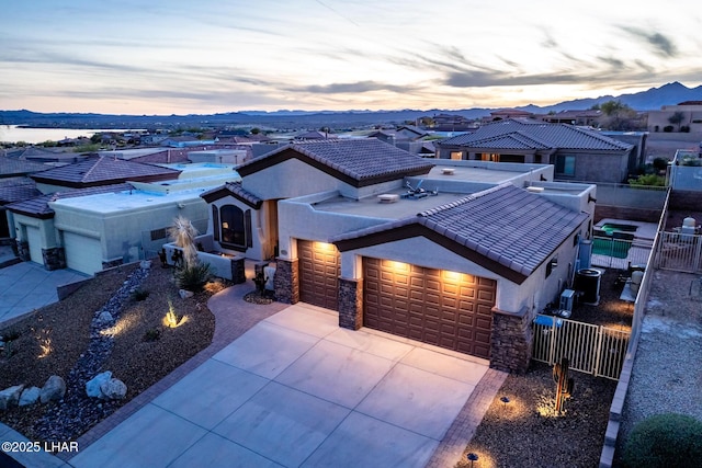 view of front of property with stucco siding, concrete driveway, an attached garage, and a tile roof