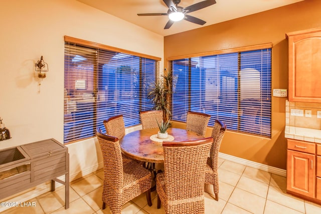 dining room featuring light tile patterned floors, baseboards, and ceiling fan