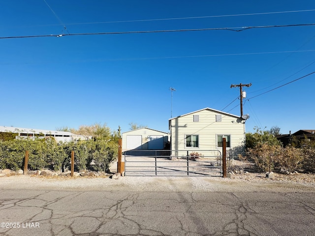 manufactured / mobile home featuring an outbuilding, fence, and a gate