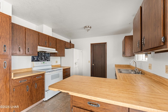 2780 Cisco Dr N, Lake Havasu City, AZ 86403 - kitchen featuring white appliances, a peninsula, under cabinet range hood, light countertops, and a sink