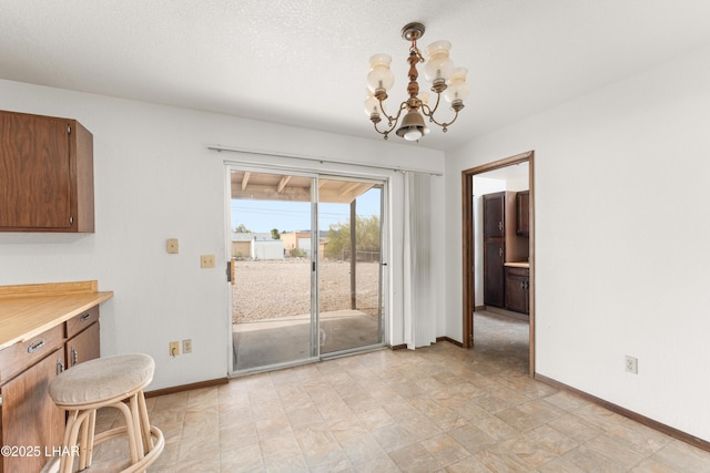 2780 Cisco Dr N, Lake Havasu City, AZ 86403 - unfurnished dining area featuring baseboards, a notable chandelier, and a textured ceiling