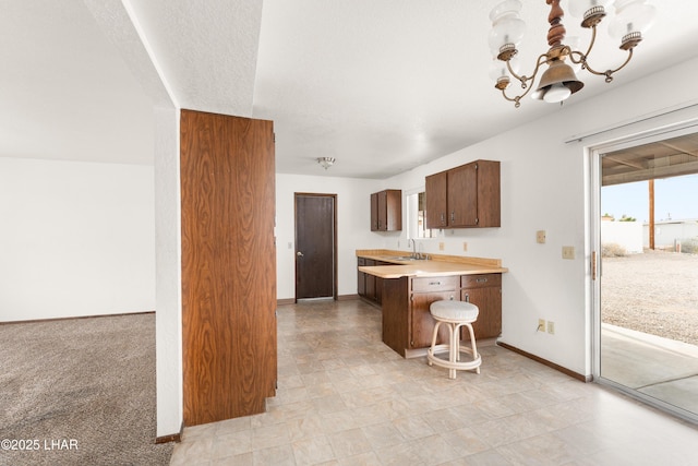 2780 Cisco Dr N, Lake Havasu City, AZ 86403 - kitchen with a sink, light countertops, a notable chandelier, and baseboards