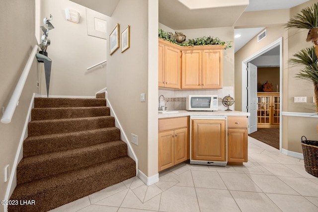8480 Miraleste Shores Dr, Parker, AZ 85344 - kitchen with white microwave, light countertops, light tile patterned floors, light brown cabinets, and backsplash