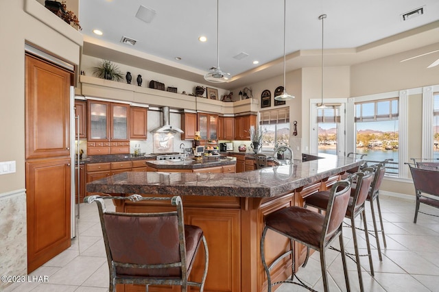 8480 Miraleste Shores Dr, Parker, AZ 85344 - kitchen with wall chimney range hood, brown cabinetry, light tile patterned flooring, and recessed lighting
