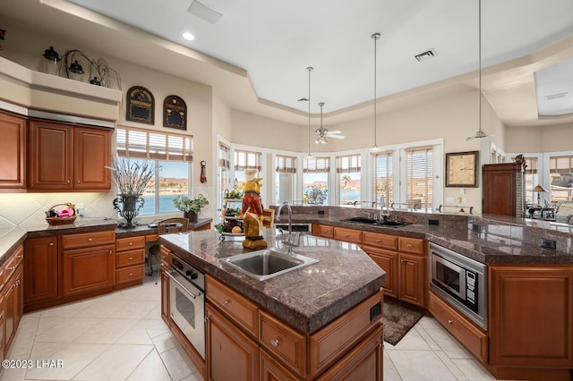 8480 Miraleste Shores Dr, Parker, AZ 85344 - kitchen with stainless steel appliances, a kitchen island with sink, brown cabinetry, and recessed lighting