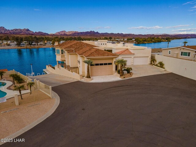 8480 Miraleste Shores Dr, Parker, AZ 85344 - view of front of house featuring a water and mountain view, a tile roof, a garage, concrete driveway, and stucco siding