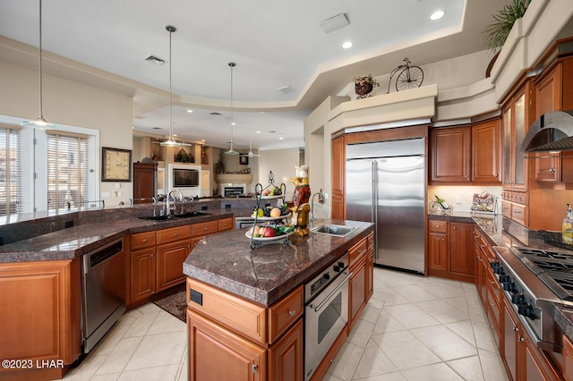 8480 Miraleste Shores Dr, Parker, AZ 85344 - kitchen with appliances with stainless steel finishes, a center island with sink, open floor plan, a tray ceiling, and light tile patterned floors
