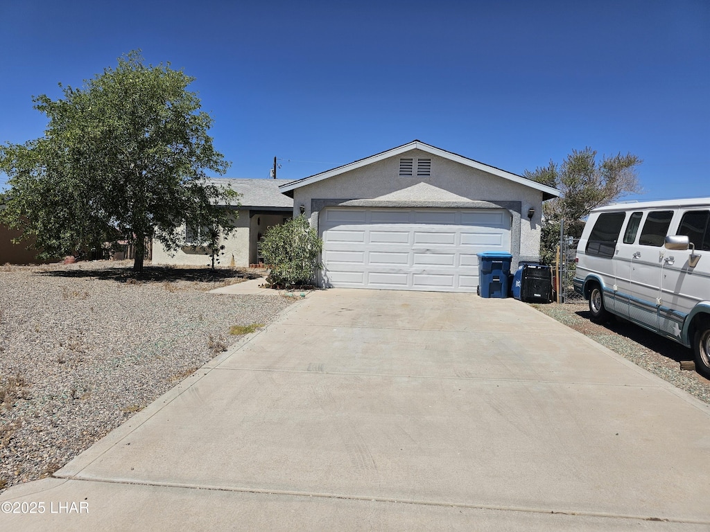 view of front facade featuring driveway, a garage, and stucco siding