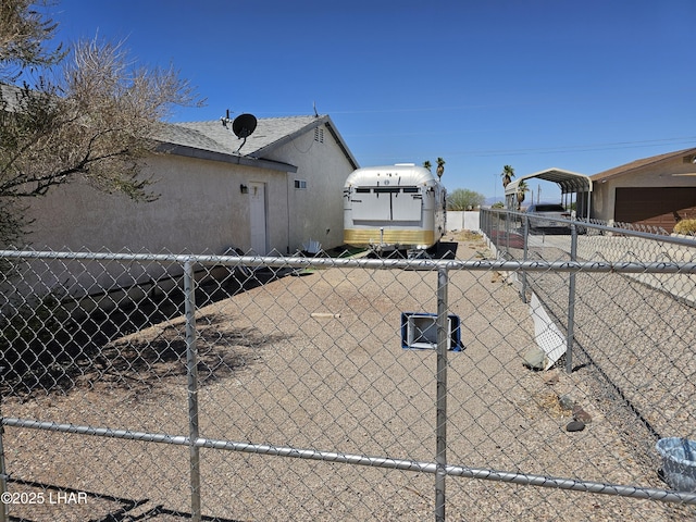 view of home's exterior with a detached carport, fence, and stucco siding