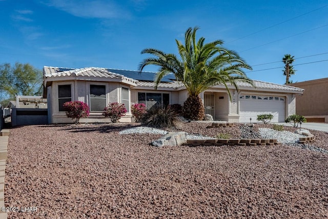 ranch-style house featuring solar panels, an attached garage, a tiled roof, and stucco siding