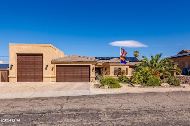 view of front of property with a garage and solar panels