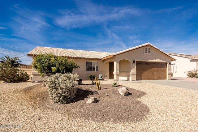 ranch-style home with a garage, a tile roof, driveway, and stucco siding