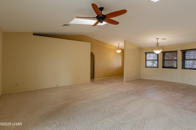 unfurnished room with light tile patterned floors, visible vents, lofted ceiling, arched walkways, and light colored carpet