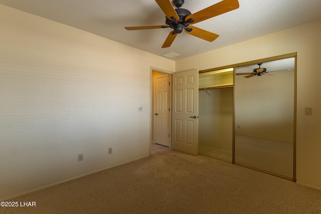 unfurnished bedroom featuring baseboards, light colored carpet, a closet, and ceiling fan