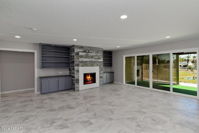 unfurnished living room featuring recessed lighting, baseboards, and a tiled fireplace