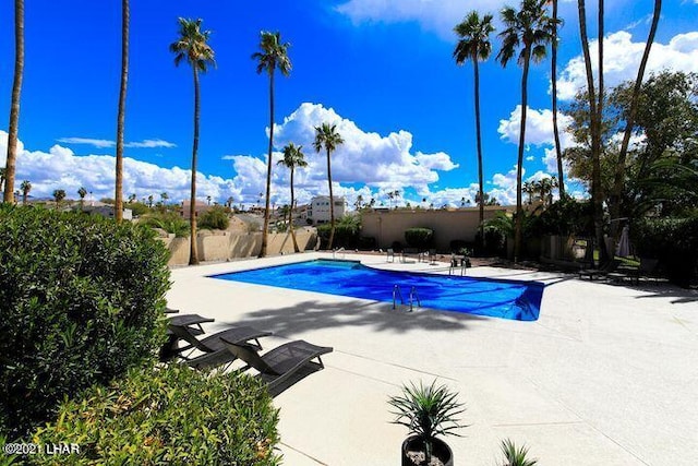 outdoor pool featuring a patio area and fence