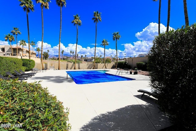 community pool featuring a patio area and a fenced backyard