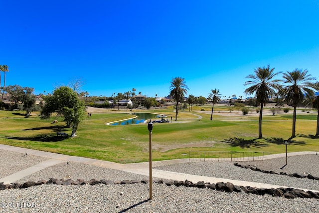 view of property's community featuring view of golf course, a lawn, and a water view