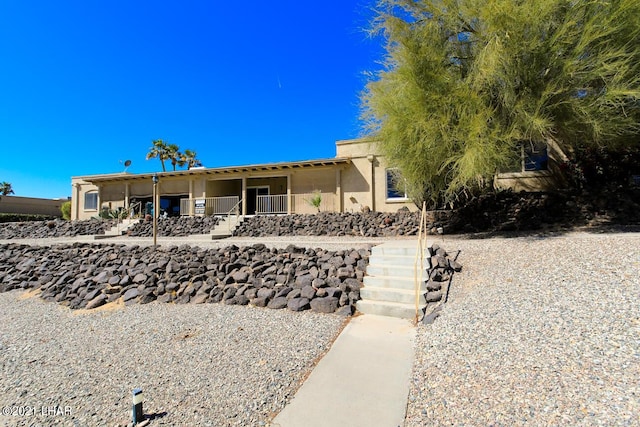 view of front of house featuring covered porch and stucco siding