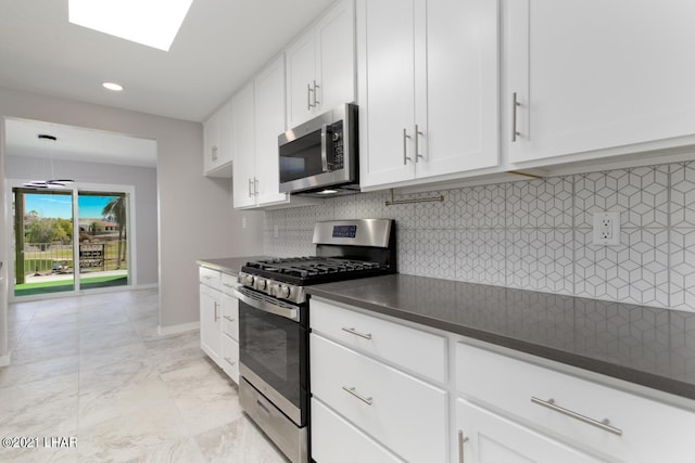 kitchen featuring appliances with stainless steel finishes, dark countertops, marble finish floor, and tasteful backsplash