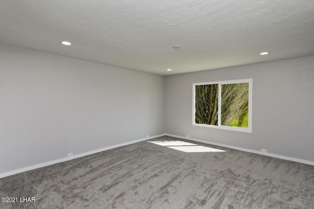 carpeted empty room featuring a textured ceiling, recessed lighting, and baseboards