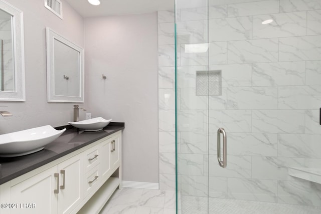 full bathroom with marble finish floor, visible vents, a sink, and a shower stall