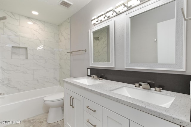 full bathroom featuring toilet, double vanity, visible vents, and a sink