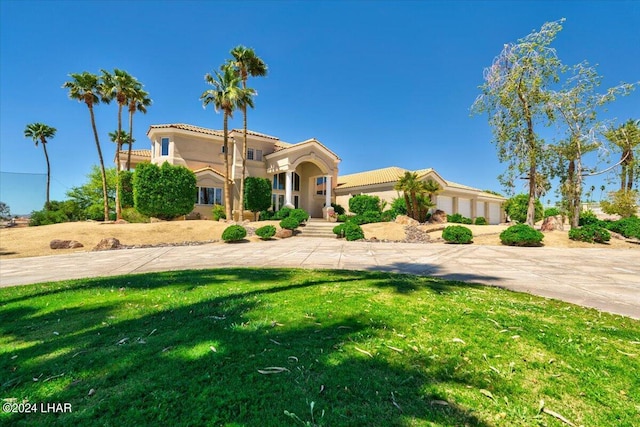 mediterranean / spanish-style home with a front lawn and a garage