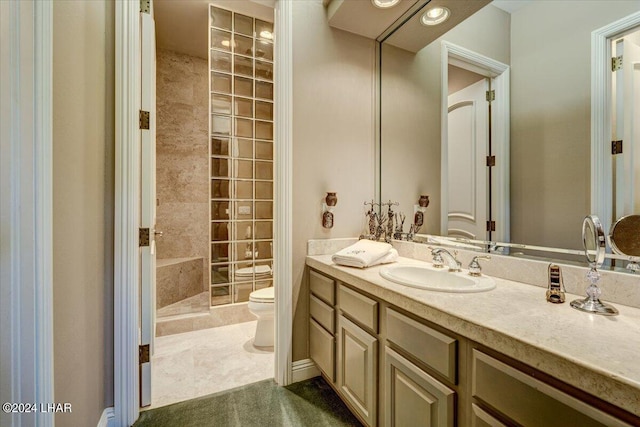 bathroom featuring toilet, vanity, and tiled shower