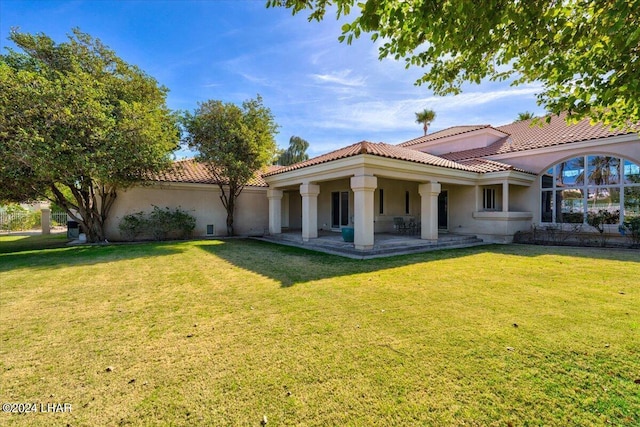 back of property featuring a lawn and a patio