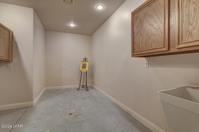 laundry area with cabinets and sink